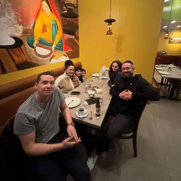 A group of people, including children, smiling at a table in Great Indian Kitchen restaurant.