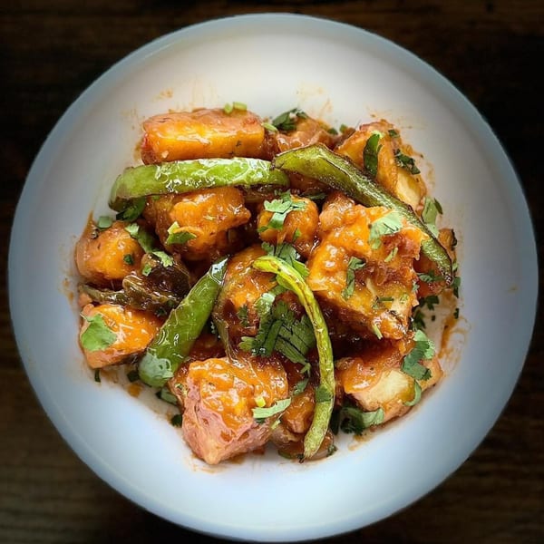 Indian chili paneer, a vibrant dish with paneer, green chilies, and cilantro in a rich sauce.